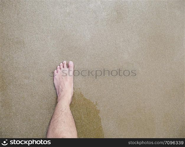 Left feet of Asian male on the beach