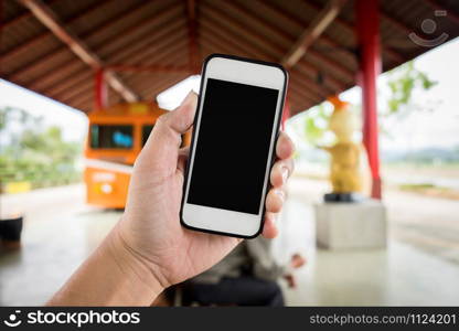 Left hand holding using smartphone with blank screen on Abstract blur background of trainstation.