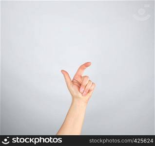 left hand with curled fingers on a gray background