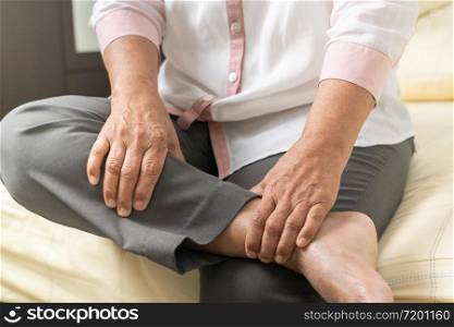 leg cramp old woman suffering from leg cramp pain at home, healthcare problem of senior concept