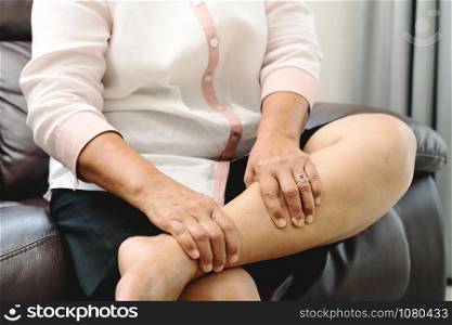 leg cramp, senior woman suffering from leg cramp pain at home, health problem concept