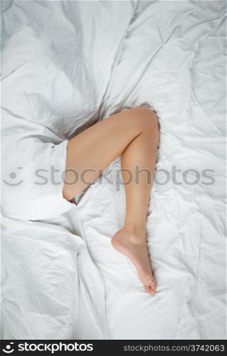 leg in bed. beautiful leg of a woman showing from under a blanket