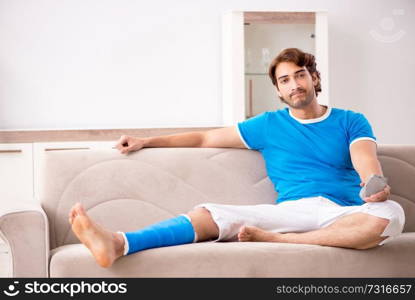 Leg injured young man on the sofa