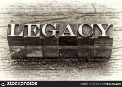 legacy word in mixed vintage metal type printing blocks over grunge wood, black and white image