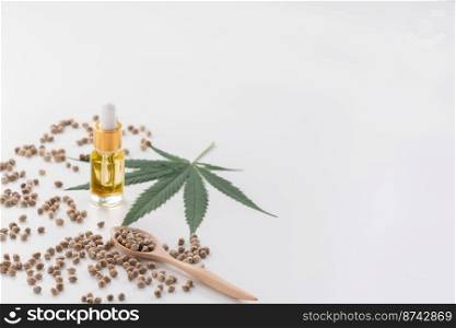 Legalized marijuana concept features with CBD oil extract from marihuana in glass bottle with dropper lid, piles of hemp seeds on empty background. Marijuana products for copyspace and advertising.. Legalized marijuana concept features with CBD oil for copyspace and advertising.