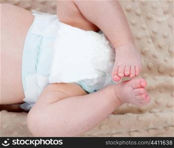 Legs of a baby with diaper on a blanket