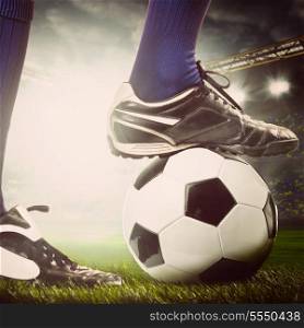 legs of a soccer or football player on ball on stadium. legs of a soccer player