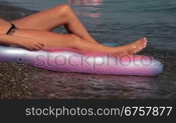 legs of a woman sunbathing on the beach