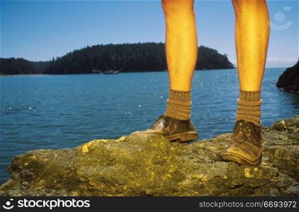 Legs of Hiker on Rocks by Ocean
