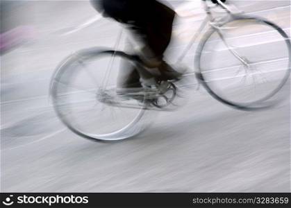 Legs of person riding bicycle.