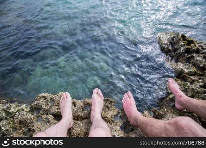 Legs of two men on the beach, relax