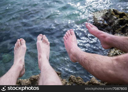 Legs of two men on the beach, relax