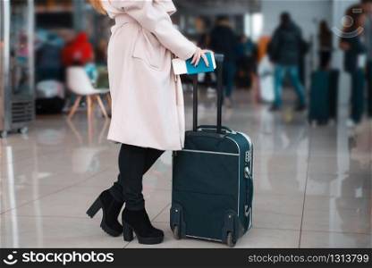 Legs of young businesswoman with baggage in airport. Travel concept.. Legs of businesswoman with baggage in airport.