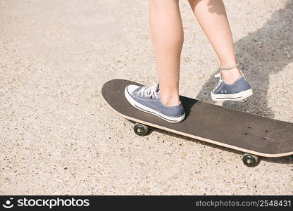 Legs of young female skateboarder skateboarding