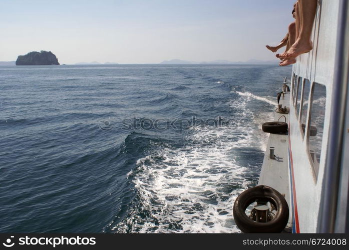 Legs on the white boat and sea