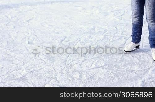 legs teenage girl drive and rotate on skating rink in winter