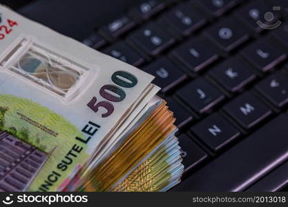 Lei banknotes on keyboard. Selective focus on stack of LEI romanian money.. Lei banknotes on keyboard. Selective focus on stack of LEI romanian money.