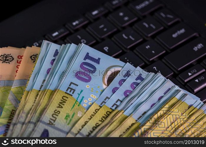Lei banknotes on keyboard. Selective focus on stack of LEI romanian money.. Lei banknotes on keyboard. Selective focus on stack of LEI romanian money.