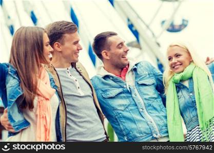 leisure, amusement park and friendship concept - group of smiling friends ferris wheel on the back