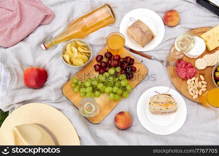 leisure and eating concept - close up of food and drinks on picnic blanket. close up of food and drinks on picnic blanket