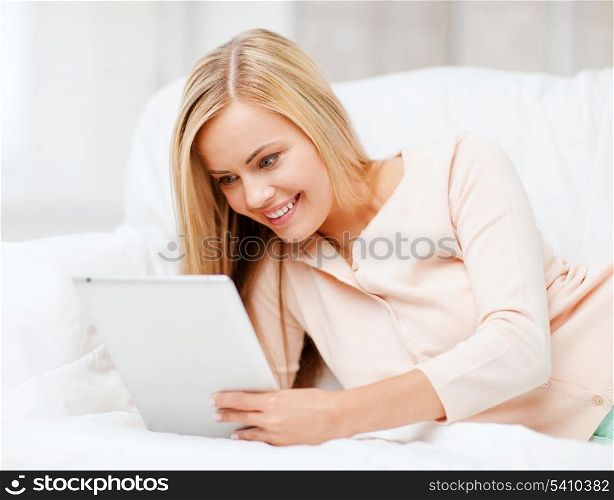 leisure and education concept - smiling woman lying on the couch with tablet pc