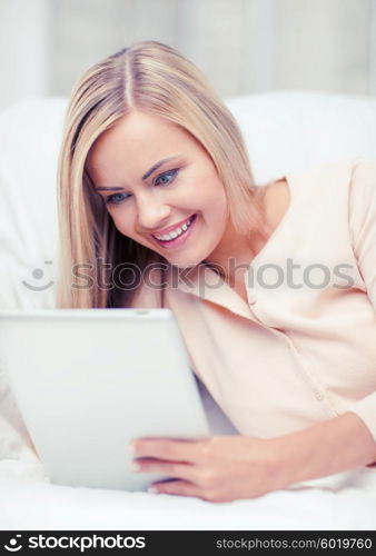 leisure and education concept - smiling woman lying on the couch with tablet pc. woman with tablet pc