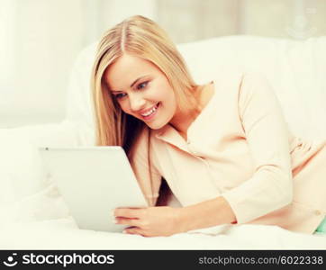 leisure and education concept - smiling woman lying on the couch with tablet pc. woman with tablet pc