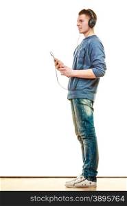 leisure and lifestyle concept. Full length young man fashion clothes with headphones mobile phone listening music isolated on white