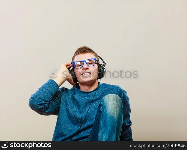 leisure and lifestyle concept. Young hipster man fashion clothes with headphones listening music.