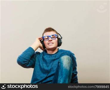 leisure and lifestyle concept. Young hipster man fashion clothes with headphones listening music.