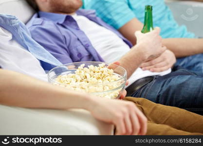 leisure and people concept - close up of friends with beer and popcorn at home. close up of friends with beer and popcorn at home