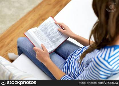 leisure and people concept - close up of teenage girl reading book at home. close up of teenage girl reading book at home