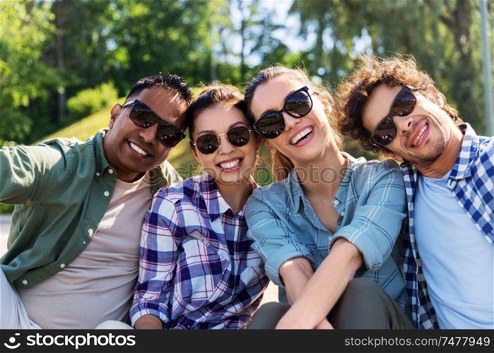 leisure and people concept - group of happy friends hanging out and taking selfie at summer park. happy friends taking selfie at summer park