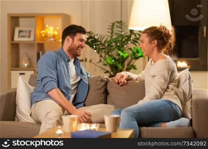 leisure and people concept - happy couple talking at home in evening. happy couple talking at home in evening