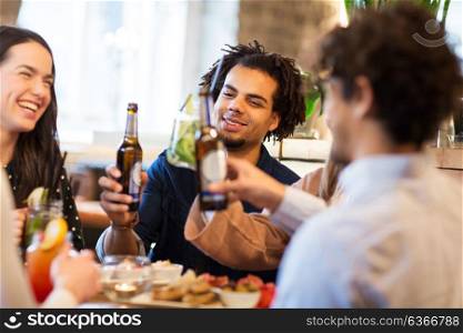 leisure and people concept - happy friends drinking non alcoholic beer at bar. happy friends drinking non alcoholic beer at bar