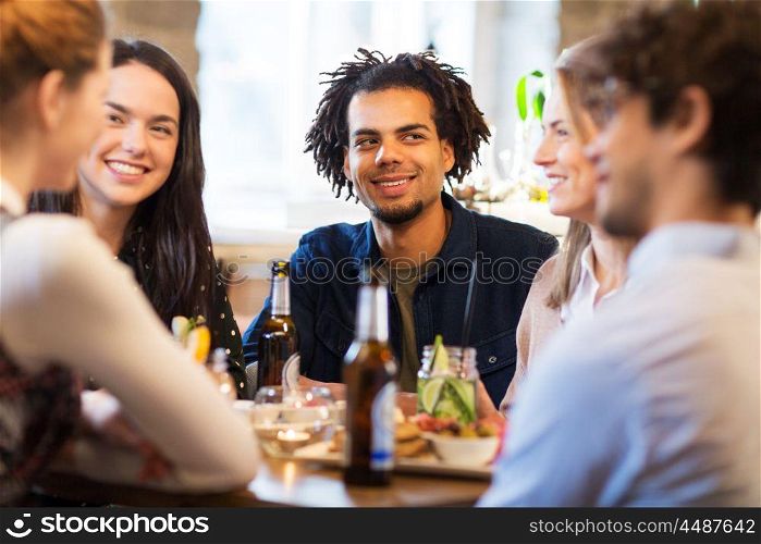 leisure and people concept - happy friends eating and drinking non-alcoholic drinks at bar or restaurant. happy friends eating at bar or restaurant. happy friends eating at bar or restaurant