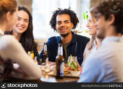 leisure and people concept - happy friends eating and drinking non-alcoholic drinks at bar or restaurant. happy friends eating at bar or restaurant. happy friends eating at bar or restaurant