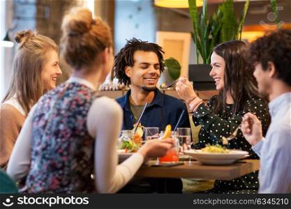leisure and people concept - happy friends eating at restaurant. happy friends eating at restaurant