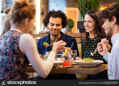 leisure and people concept - happy friends eating at restaurant. happy friends eating at restaurant