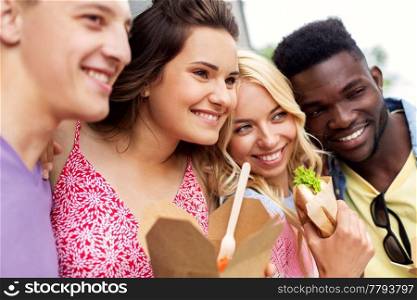 leisure and people concept - happy friends with takeaway food outdoors. happy friends with takeaway food outdoors