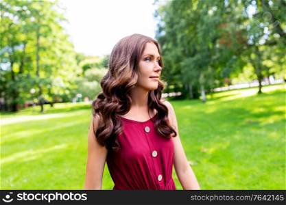 leisure and people concept - portrait of beautiful woman with long wavy hair at summer park. portrait of beautiful woman at summer park