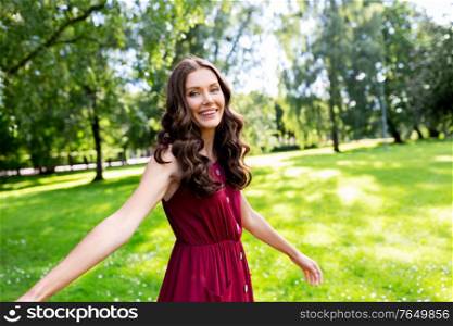 leisure and people concept - portrait of happy smiling beautiful woman with long wavy hair at summer park. portrait of happy smiling woman at summer park