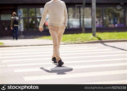 leisure and people concept - senior man walking along summer city crosswalk. senior man walking along city crosswalk