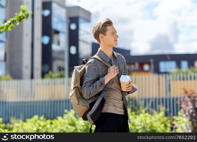 leisure and people concept - young man or teenage boy with backpack drinking takeaway coffee in city. young man with backpack drinking coffee in city