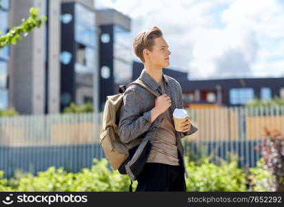 leisure and people concept - young man or teenage boy with backpack drinking takeaway coffee in city. young man with backpack drinking coffee in city