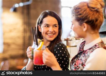 leisure, celebration and people concept - happy friends clinking drinks at restaurant. happy friends clinking drinks at restaurant