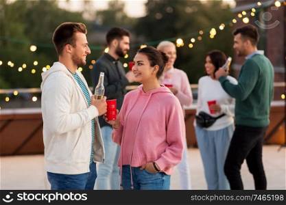 leisure, celebration and people concept - happy friends with drinks in party cups toasting at rooftop. friends with drinks in party cups at rooftop