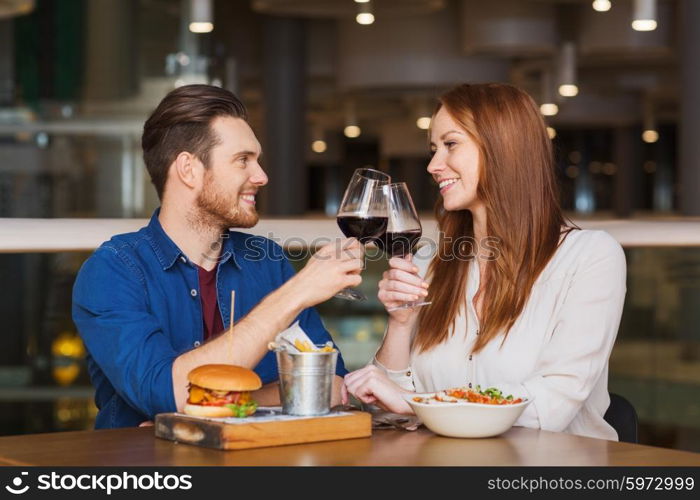 leisure, celebration, food and drinks, people and holidays concept - smiling couple having dinner and drinking red wine at date in restaurant