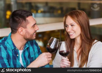 leisure, celebration, food and drinks, people and holidays concept - smiling couple having dinner and drinking red wine at date in restaurant