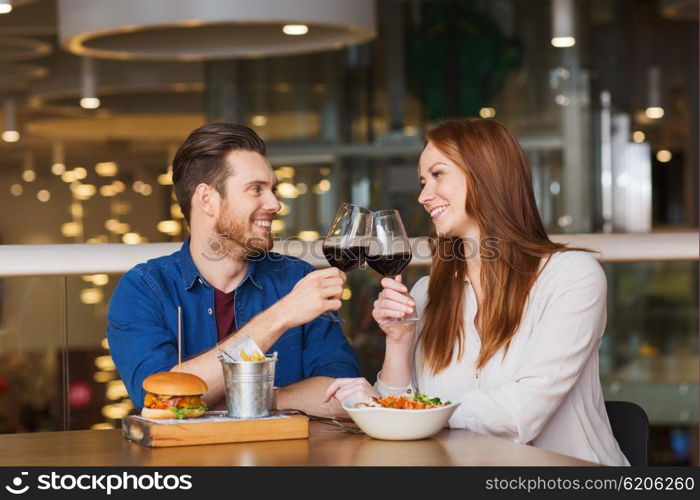 leisure, celebration, food and drinks, people and holidays concept - smiling couple having dinner and drinking red wine at date in restaurant